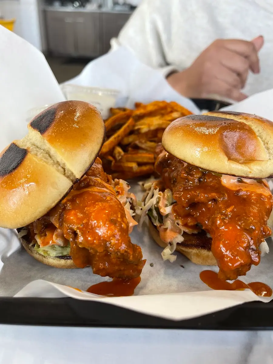 Customer photo: two saucy buffalo chicken sandwiches with seasoned fries at Wing Kings Zaragoza
